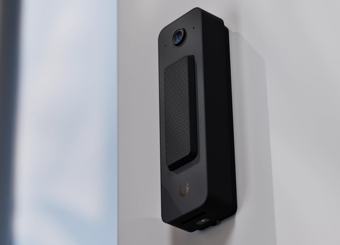 Ubiquiti Doorbell Lite zamontowane na ścianie, z kamerą i przyciskiem w kształcie prostokąta. Obudowa czarna