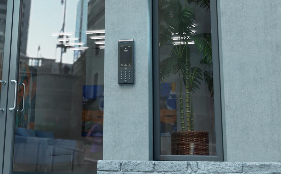 Ubiquiti UA-G3 Intercom, zamontowany na ścianie, wyświetla ekran z klawiaturą numeryczną i funkcjami urządzenia, w tle widać detale budynku