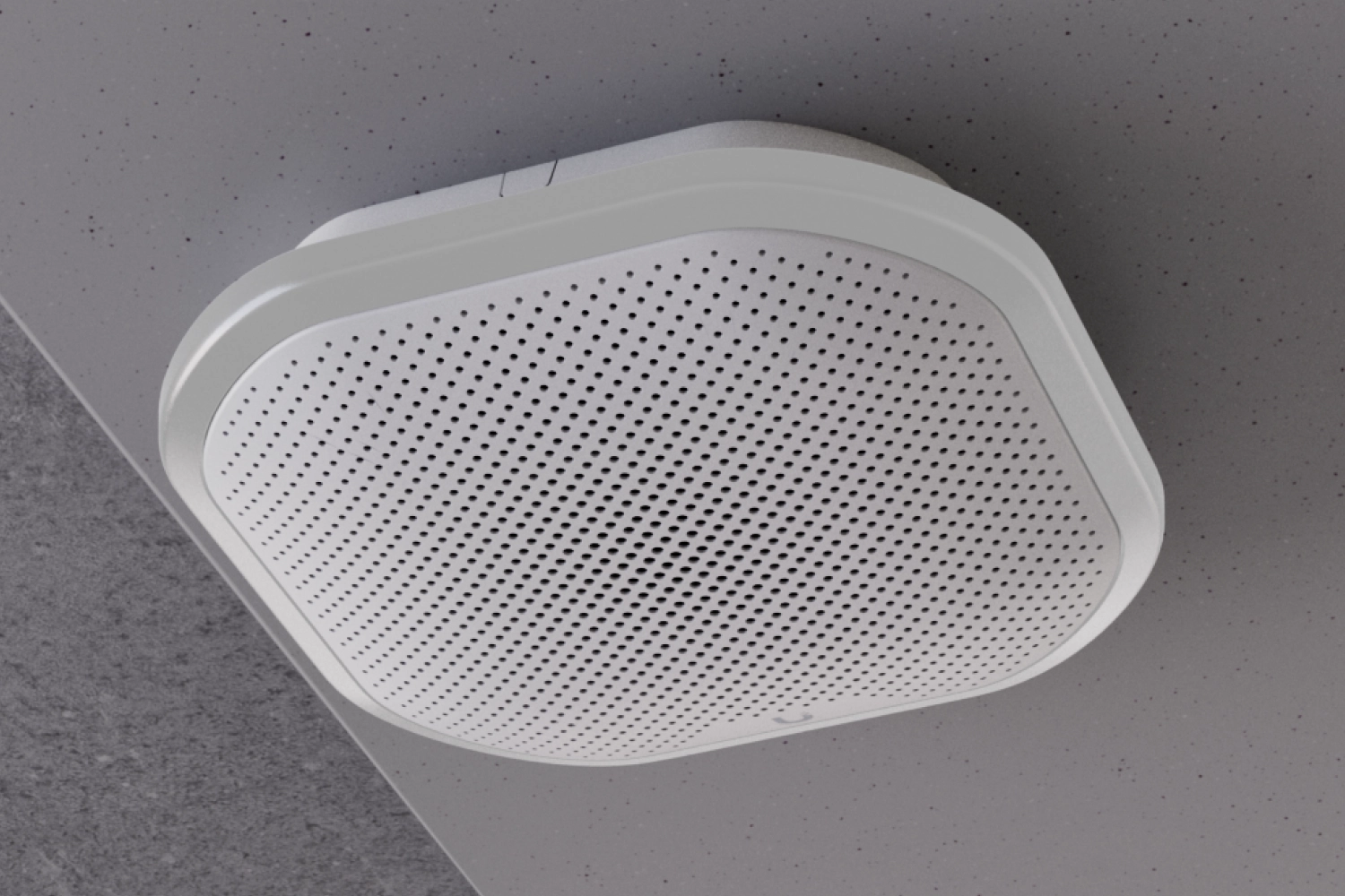 Ubiquiti UP-Siren PoE zamontowana na suficie jako biała perforowana jednostka o zaokrąglonych krawędziach